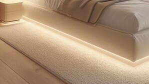Una camera da letto moderna con un letto, comodini e una parete con listelli di legno verticali.