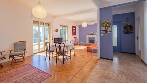 Un salón amplio con zona de comedor, chimenea y un ventanal grande.