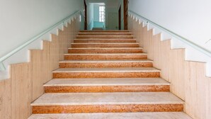 Una escalera de madera con barandillas blancas que lleva a una puerta en la parte superior.
