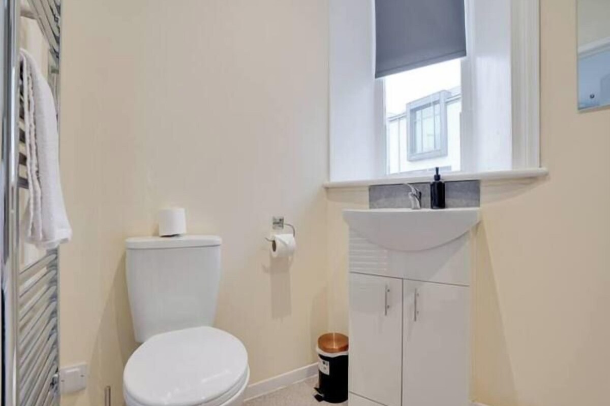 Un baño pequeño y limpio con inodoro, lavabo y armarios para guardar objetos.