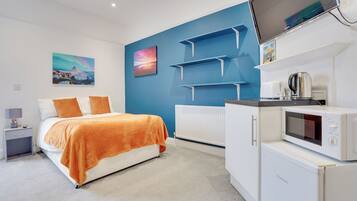 Relax in a spacious room with a large bed, flat-screen TV, and kitchenette.