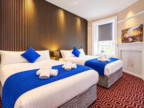A hotel room with two beds, a large window, a fireplace, and a cityscape view. - Homesly Guest Rooms - Self Checkin (Berwick-upon-Tweed)