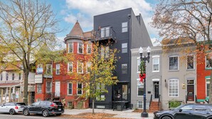 A row of multi-story buildings with a mix of architectural styles, including a red brick building with a turret and a modern black building with a flat roof. - Capitol Hill Suites - Unit 9 (Washington)