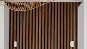 Ein Bett mit weißer und beiger Bettwäsche, eine Wand aus Holzleisten und zwei an der Wand befestigte Leuchten.