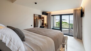 Quarto com cama grande, roupeiro embutido, televisão e varanda com vista.