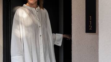 Eine Person steht in einer Türöffnung, an der Wand befindet sich ein Schild mit der Nummer 112.
