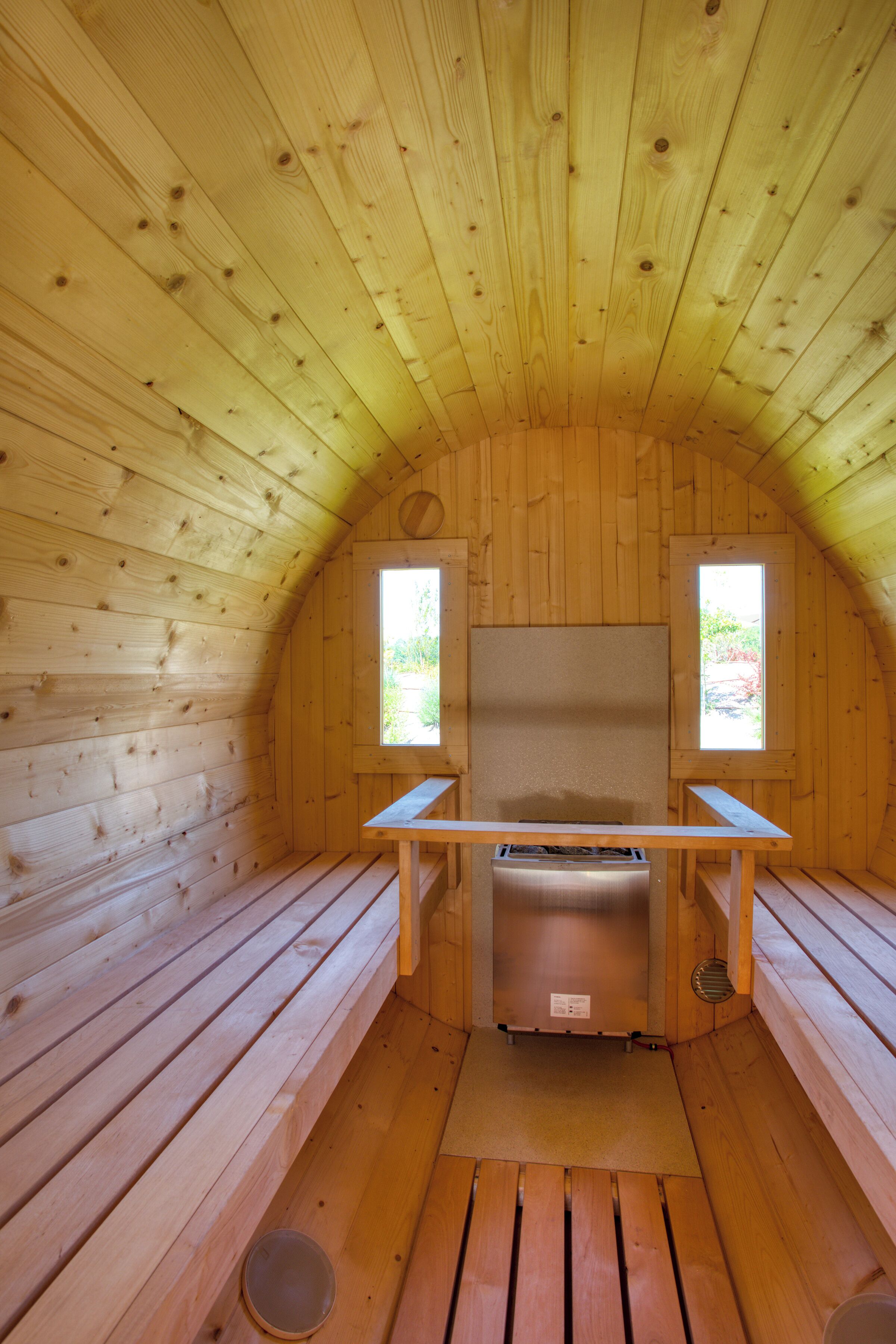 A wooden cabin with a bench, a table, and a window.