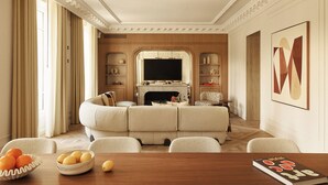 Sala de estar com lareira, sofá e área de jantar com mesa e cadeiras.