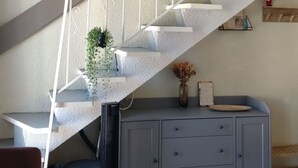 A staircase with white railings and a grey cabinet below. - Lovely studio in Amélie-les-Bains. Ideal for a spa treatment in the heart of Vallespir! (Amélie-les-Bains-Palalda)