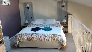 A bedroom with a bed, two nightstands, a dresser, and a staircase. - Lovely studio in Amélie-les-Bains. Ideal for a spa treatment in the heart of Vallespir! (Amélie-les-Bains-Palalda)