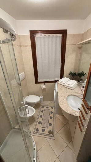 Een douche, een haardroger, een bidet, handdoeken