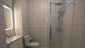 Ein Badezimmer mit Toilette, Waschbecken und Dusche.