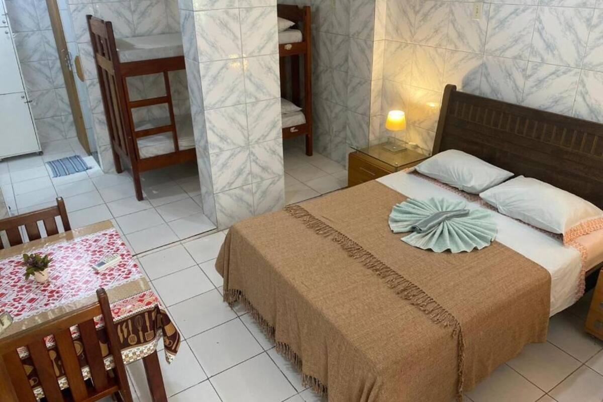 A bedroom with a bed, bedside table, and a small table with chairs.