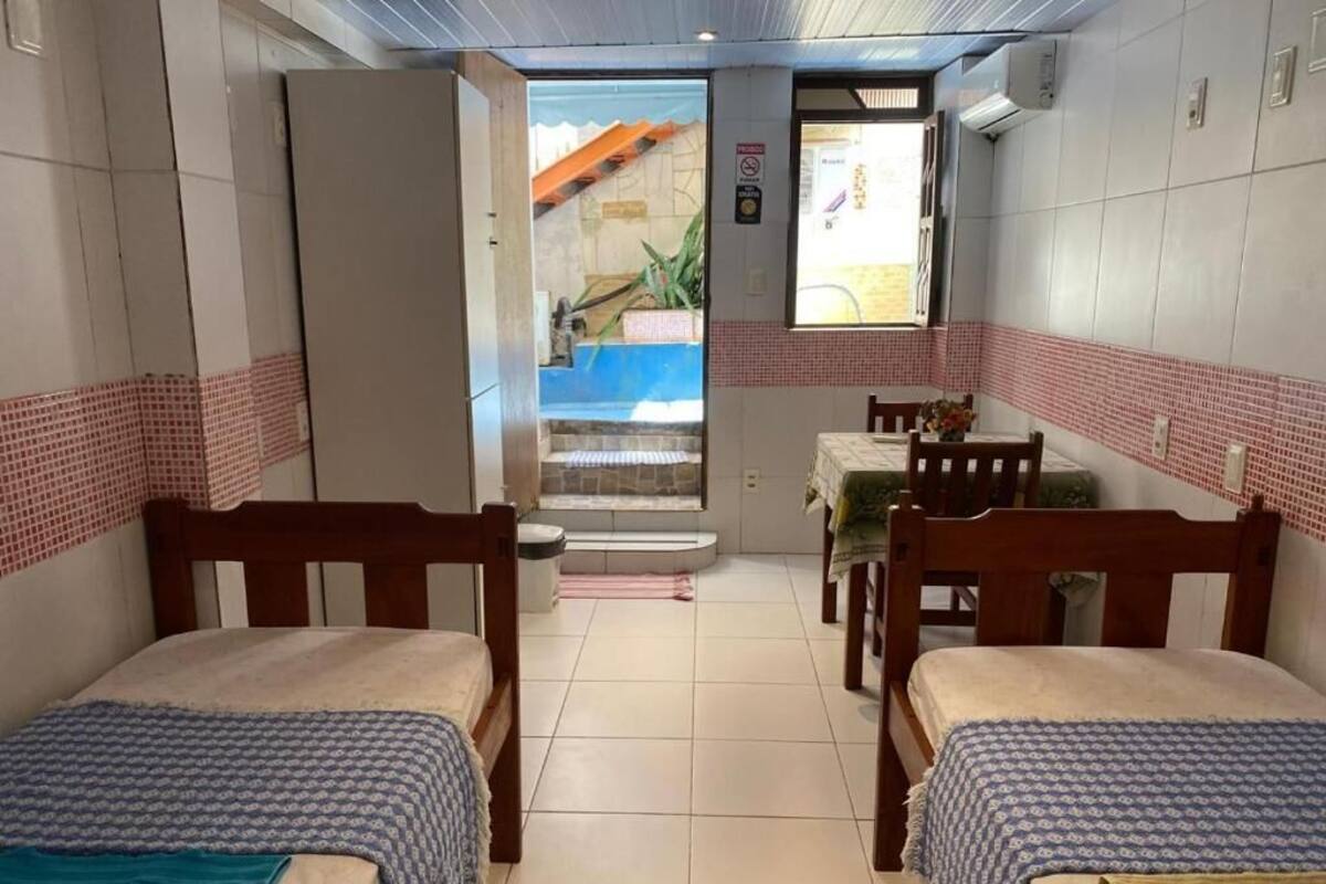 A room with two beds, a small table, and a window.