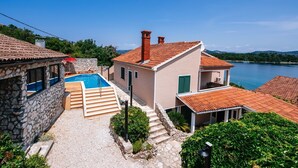 A coastal villa with a swimming pool, stone walls, and a view of the sea. - A relaxing beachside house with a hot tub overlooking the sea in Zadar County. (Zadar County)