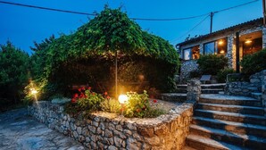 A stone staircase leading to a stone building with a garden area featuring a lamp post and flowering plants. - A relaxing beachside house with a hot tub overlooking the sea in Zadar County. (Zadar County)
