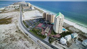 Ein Küstenhotel mit mehreren Hochhäusern, einem Parkplatz und einem Strand.