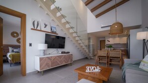 A modern living room with a staircase, a dining area, and a kitchen. - Exclusive Penthouse With Picuzzi Steps From Beach (Punta Cana)