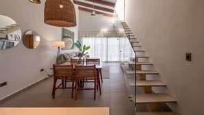 A modern interior with a dining area, staircase, and a view to the upper floor. - Exclusive Penthouse With Picuzzi Steps From Beach (Punta Cana)
