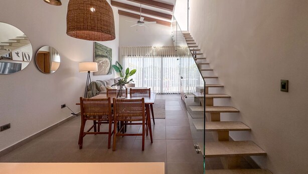 A modern interior with a dining area, staircase, and a view to the upper floor. - Exclusive Penthouse With Picuzzi Steps From Beach (Punta Cana)