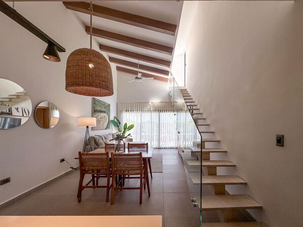 A modern interior with a dining area, staircase, and a view to the upper floor. - Exclusive Penthouse With Picuzzi Steps From Beach (Punta Cana)