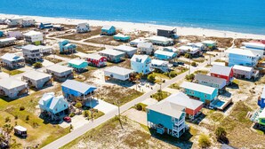 Vista aérea de una zona residencial costera con casas, una playa y el océano.