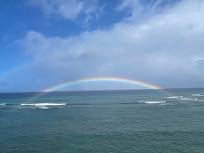 A clear view of the ocean with a rainbow arching over the water.