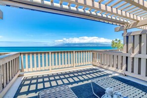A balcony with a view of the ocean and a distant mountain.
