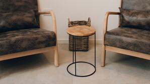 A room with two dark brown upholstered chairs, a small round wooden table, and a woven basket. - Suite 13 B - San Lorenzo Suites (Putignano)