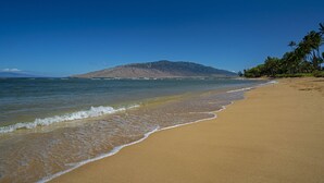 A beach with a clear view of the ocean and a mountain in the distance. - Waiohuli Beach Hale C212 (Kihei)