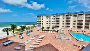 Un hotel con piscina, vistas a la playa y varios balcones.