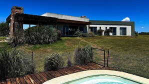 A modern house with a swimming pool, surrounded by a well-maintained lawn and various plants. - La Colina by Carmelodays (Carmelo)
