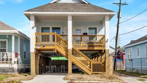 Un immeuble de deux étages doté d’un balcon et d’un escalier menant à l’étage supérieur.