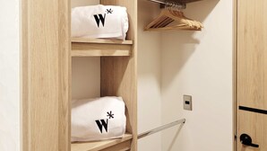 A wooden wardrobe with two shelves holding white towels with black 'W' symbols. - w Elegant 2BR w Amazing Deco in Medellin (Medellín)