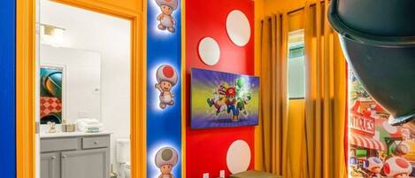A room with a red and blue wall, a painting of Mario and Luigi, and a Nintendo 64 console.