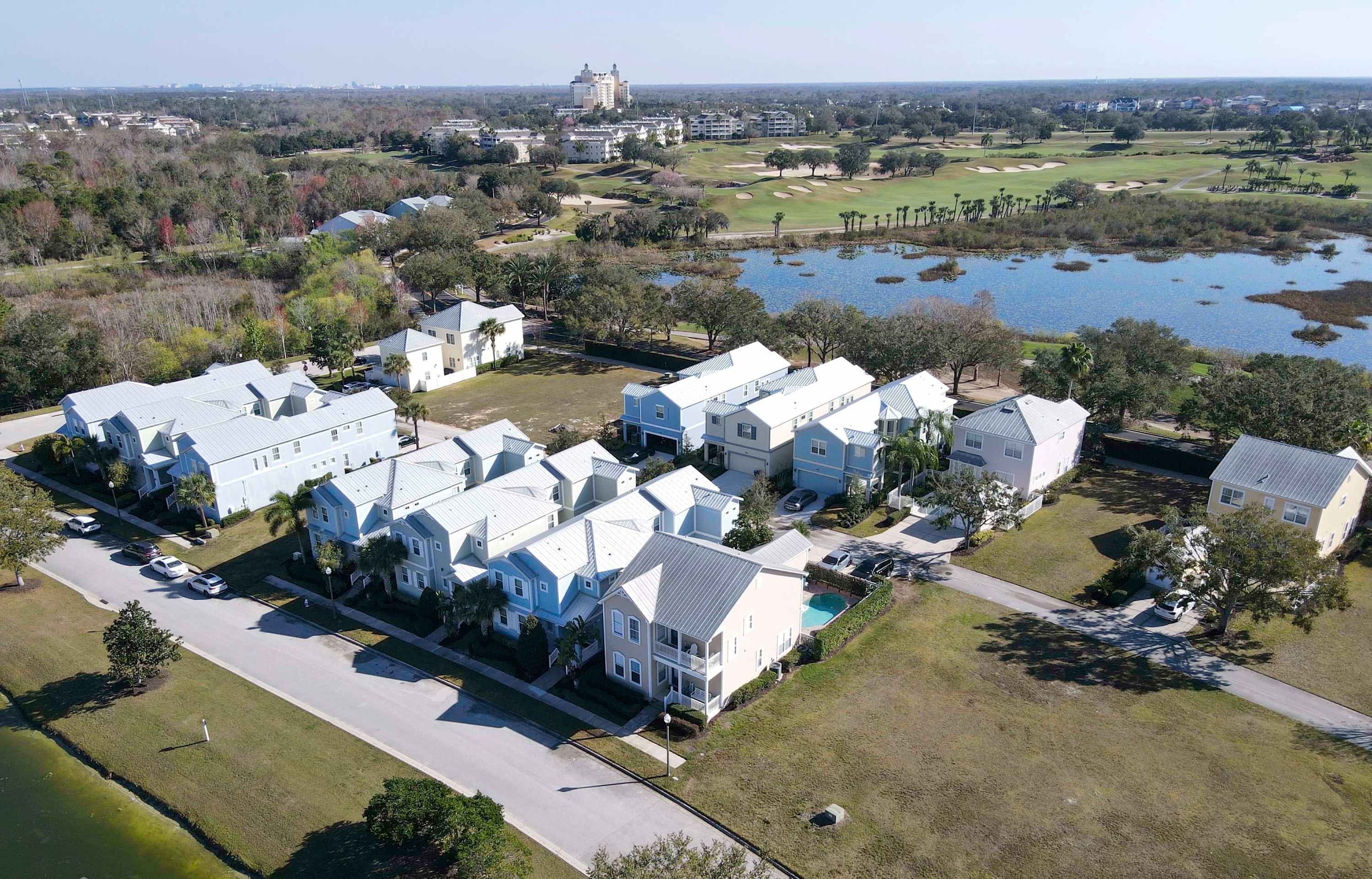 A residential area with houses, a golf course, and a body of water.