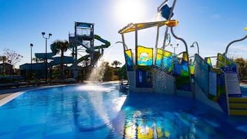 A water park with a large pool, water slides, and a water feature spraying water.