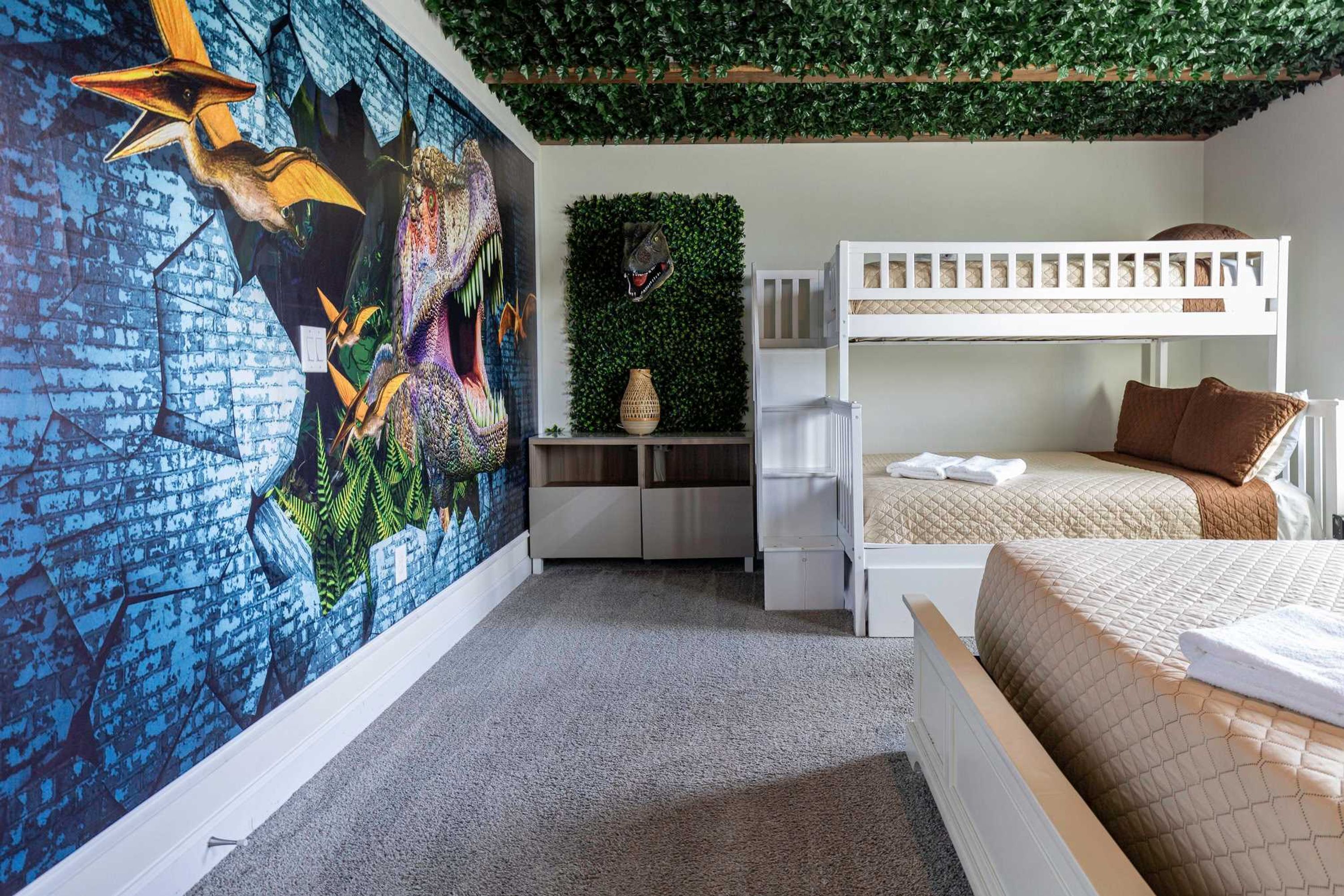 Une chambre avec des lits superposés, une fresque murale et un mur végétal.