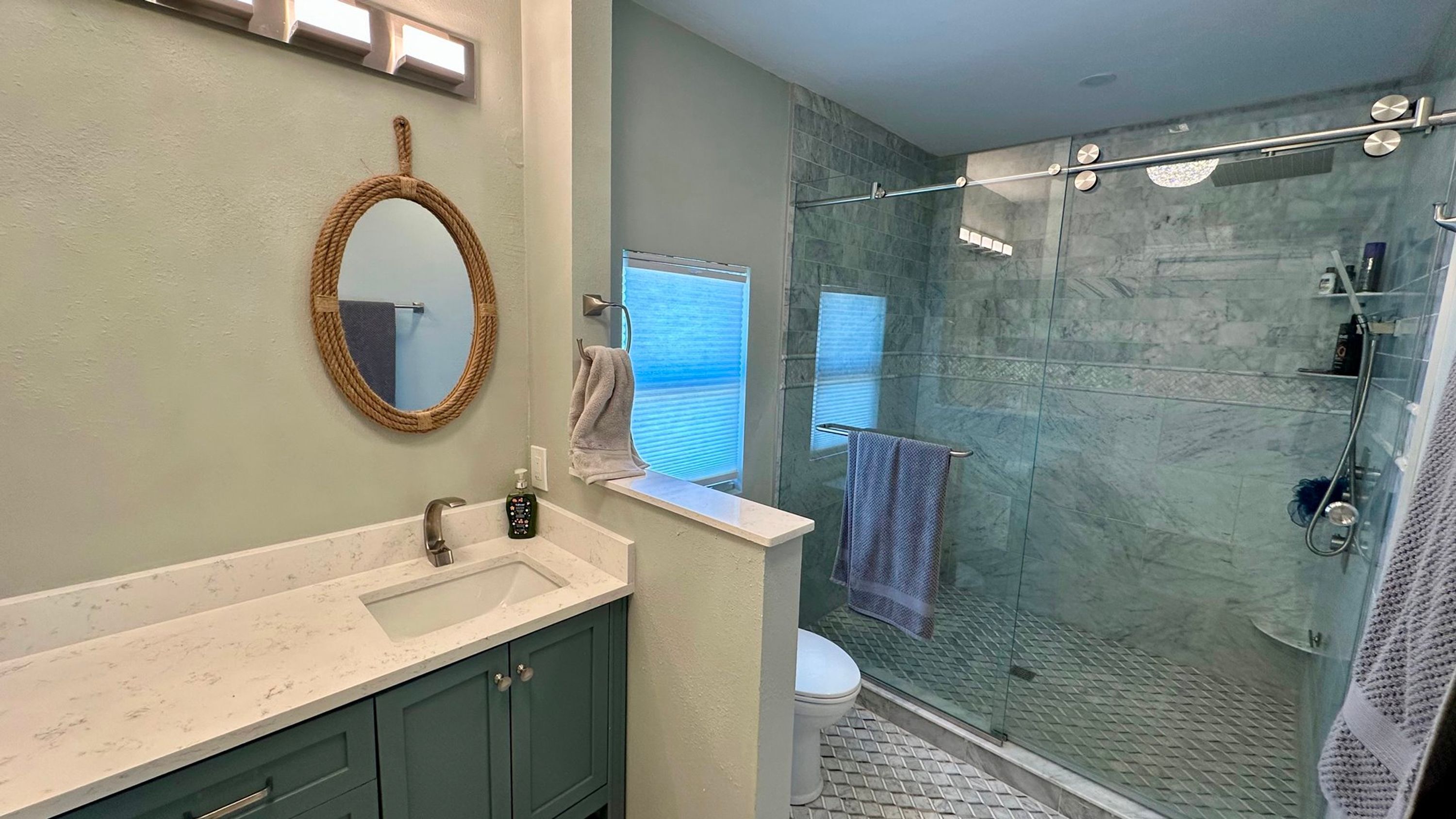 Une salle de bain avec un lavabo, un miroir et une douche.