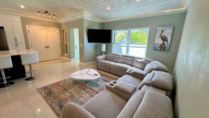 Ein modernes Wohnzimmer mit einem Ecksofa, einem Couchtisch und einem Flachbildfernseher.