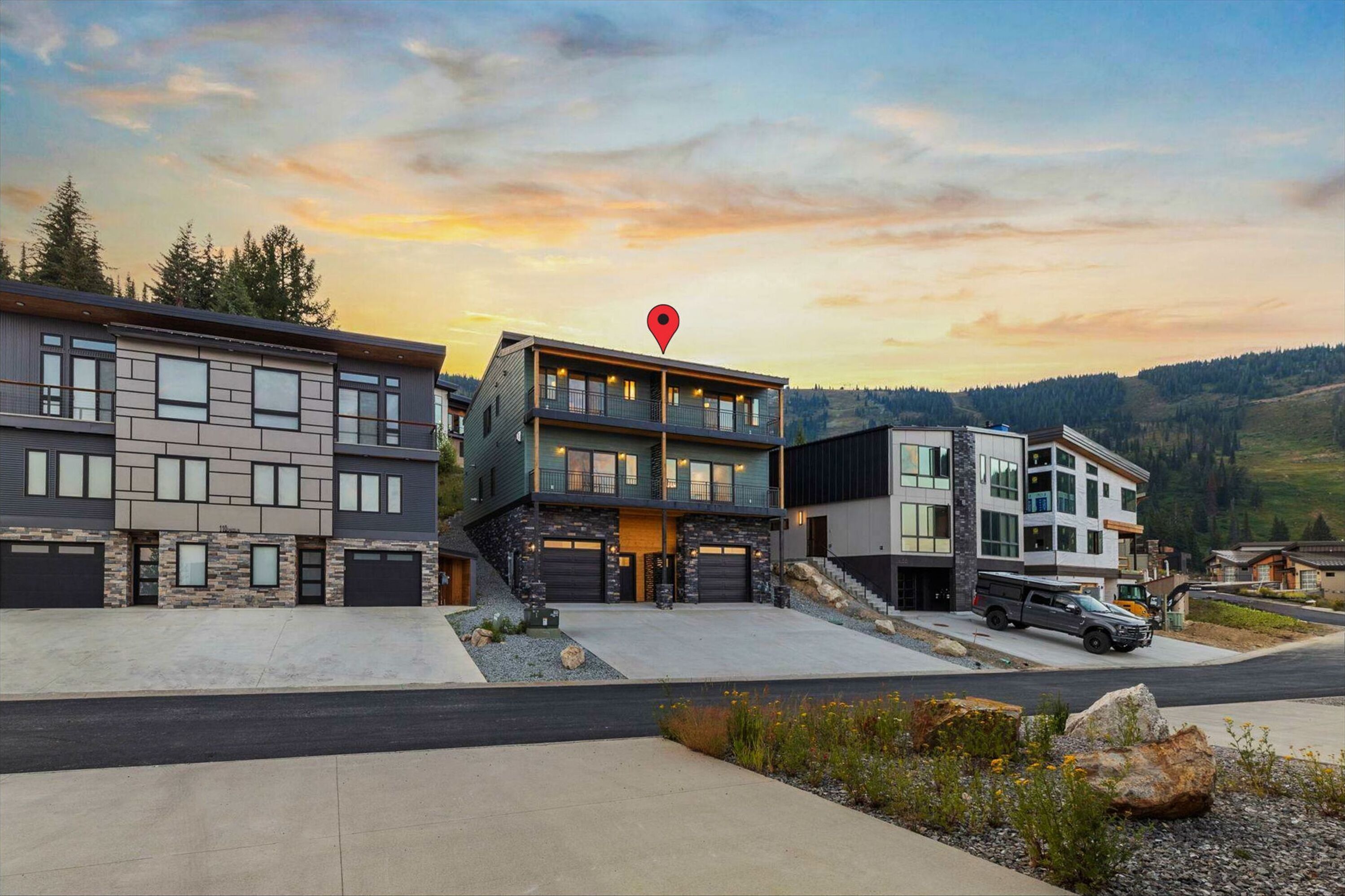 Un área residencial moderna con casas contemporáneas, una entrada para vehículos y un SUV estacionado.