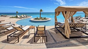 A poolside area with lounge chairs and a canopy, overlooking a clear blue sea. - Luxury New Oceanfront Condo 5BR Sleeps 12 (Puerto Peñasco)