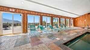 Une piscine intérieure avec des chaises longues et un panneau indiquant la sortie.