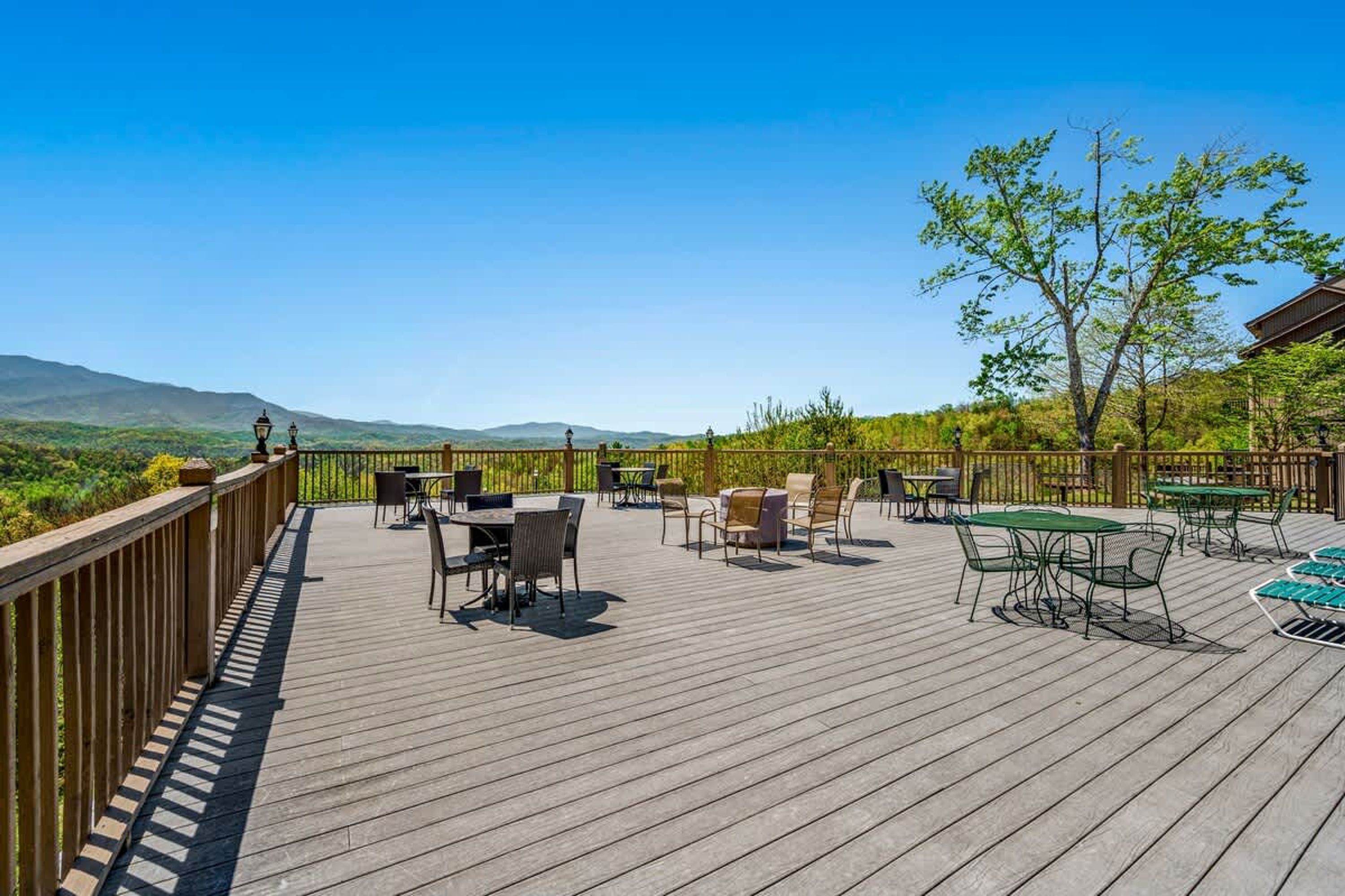 A wooden deck with outdoor seating and a view of the mountains.