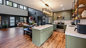 Una cocina moderna con una isla central, electrodomésticos integrados y una zona de comedor con sofá y mesa.
