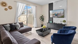 A modern living room with a sofa, armchairs, a coffee table, and a TV mounted on the wall. - Magical Getaway in the Best Location for a Perfect Vacation (Davenport)