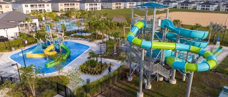 A water park with multiple slides and a pool area, surrounded by residential buildings.