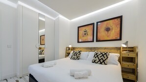 A modern bedroom with a large bed, bedside tables, and artwork on the walls. - GuestReady - A lovely home near Plaza Mayor (Madrid)
