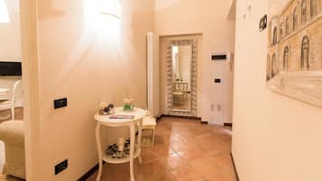 A hallway with a white table, a mirror, and a tiled floor.