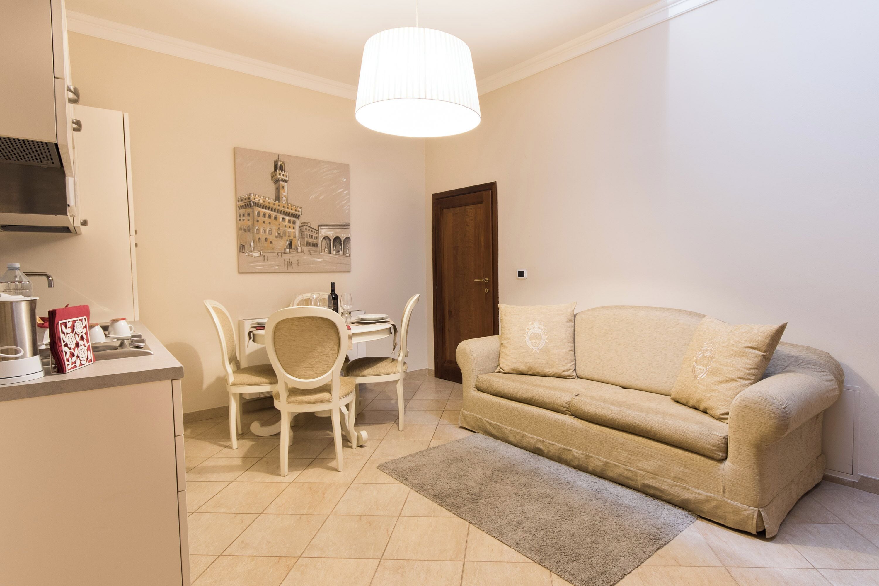 A compact living space with a kitchenette, a dining area, and a sofa.